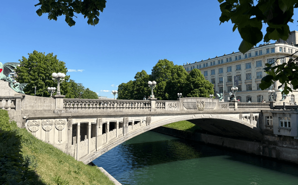 Sonnige Drachenbrücke in Ljubljana mit Drachenstatuen von der Seite