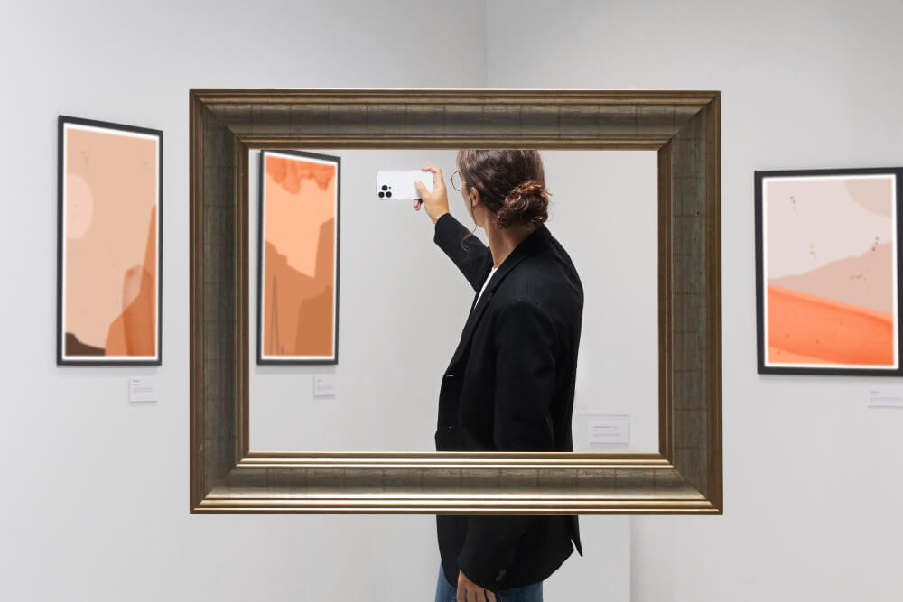 Frau mit Handy macht Foto in Kunstausstellung