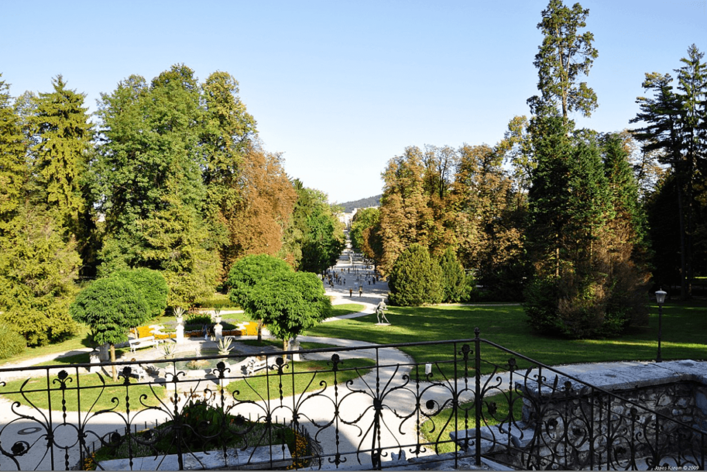 Tivoli Park mit großen Grünflächen und Bäumen sowie einem Geländer im Vordergrund