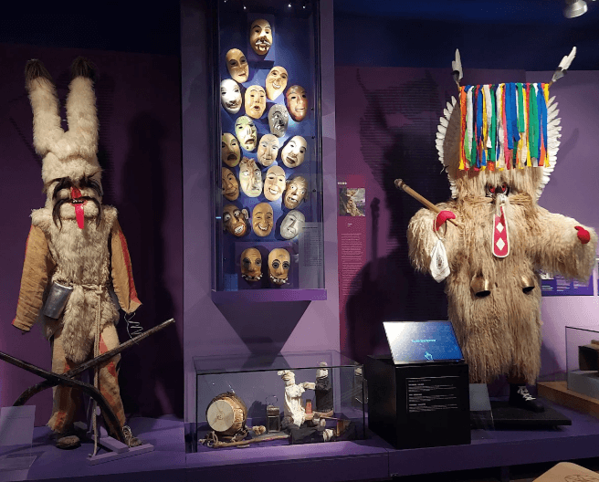 Ausstellung von zwei Statuen und Masken im Slowenischen Ethnographischen Museum in Ljubljana