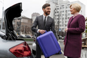 Fahrer lädt Koffer von reisender Frau in den Kofferraum beim Beginn des Flughafen Transfer Ljubljana